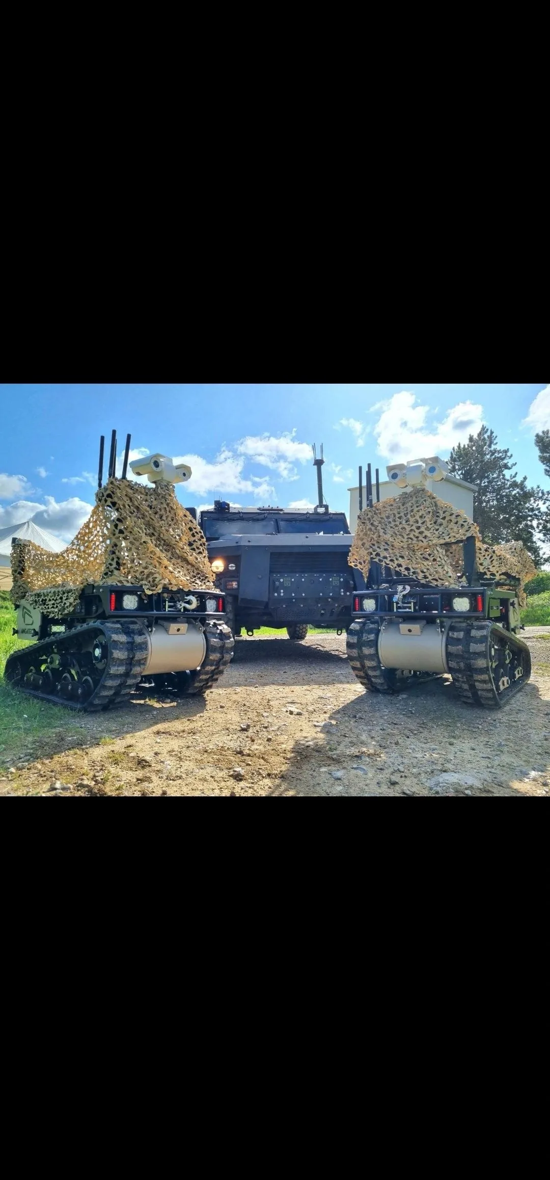 Two MAX1 vehicles under camouflage netting