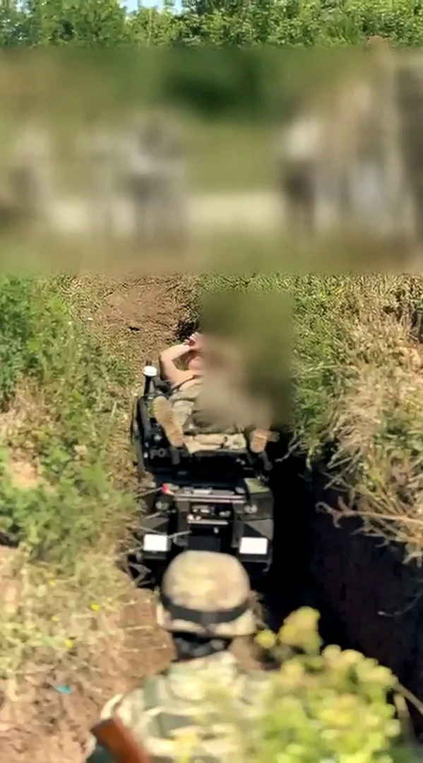 MAX1 carrying a stretcher out of a trench, faces blurred